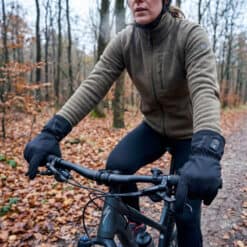 Vrouw draagt verwarmde fietshandschoenen terwijl zij door het bos fietst.