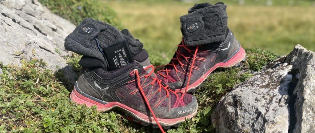 Verwarmde sokken in bergwandelschoenen op rotsen