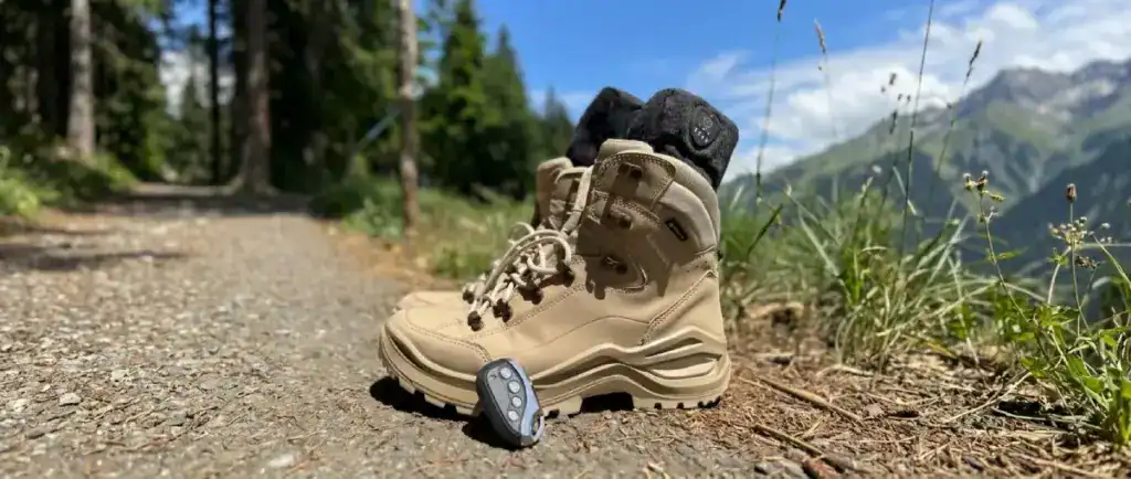 Verwarmde sokken in een paar wandelschoenen. Afstandsbediening ligt op de schoenen.