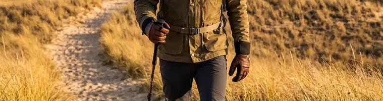 Persoon aan het wandelelen in de duinen met verwarmde handschoenen