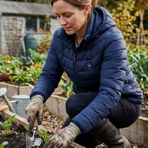 Vrouw met verwarmde jas is aan het tuinieren.